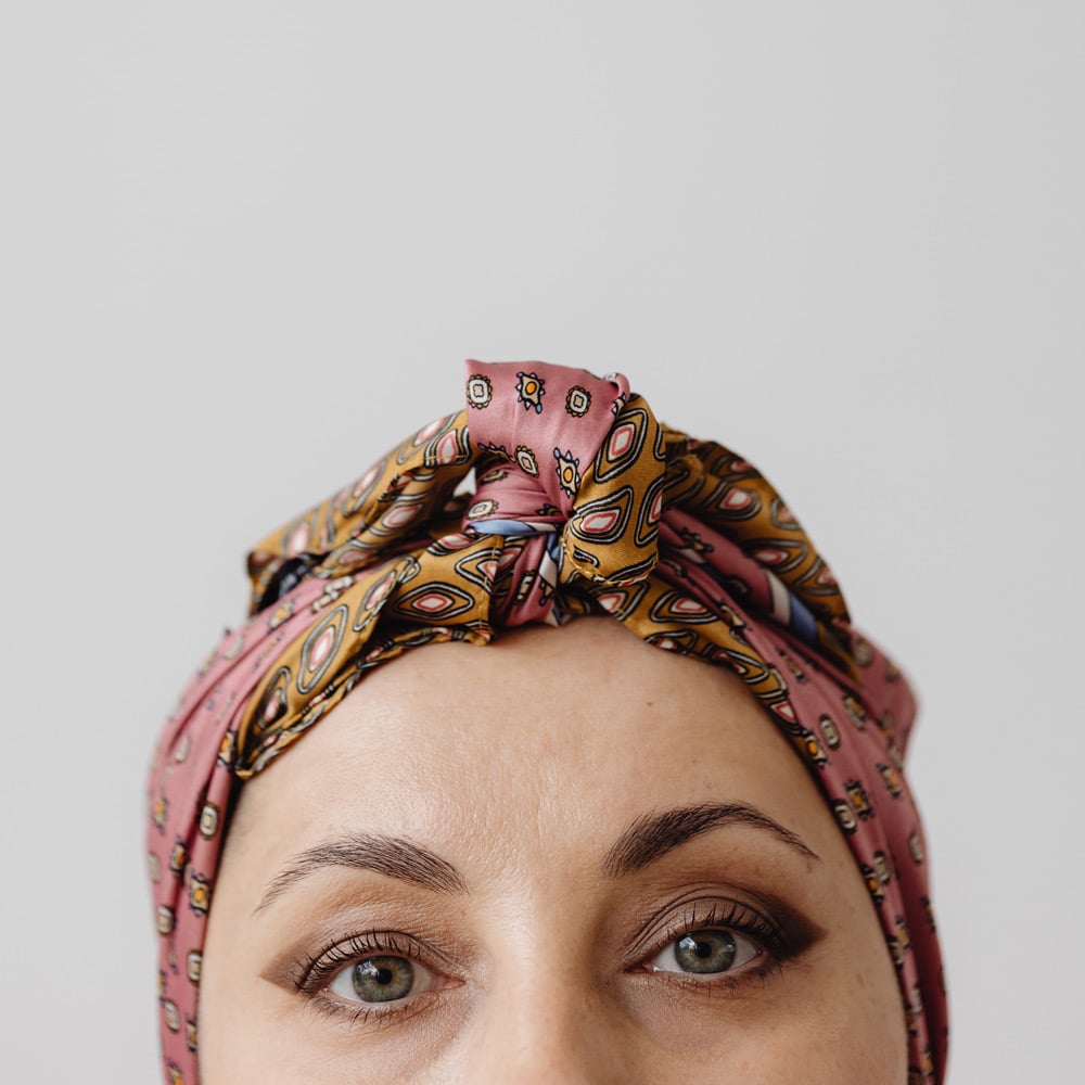 An image of a white woman wearing a headscarf, looking directly at the camera.